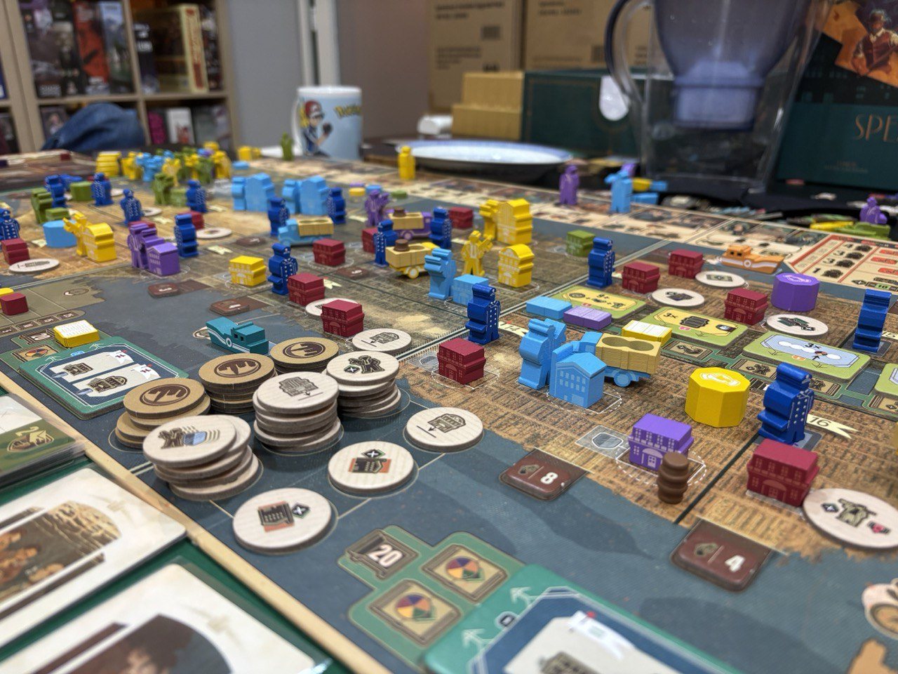 Mesa de jogo cheia de peças e cartas numa noite de jogos